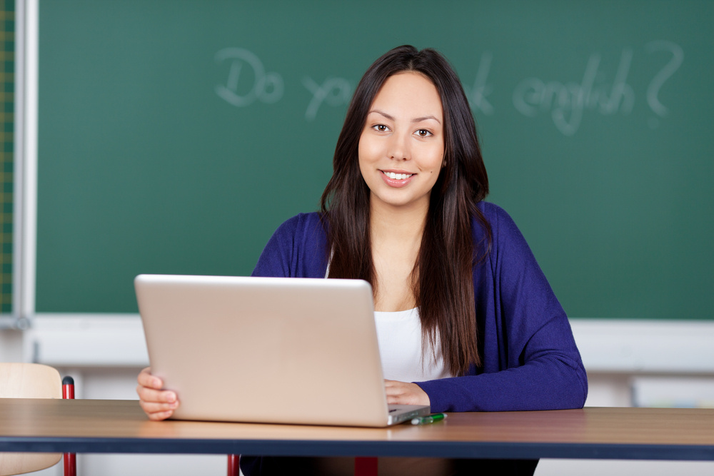 young woman using laptop at english lesson in class room